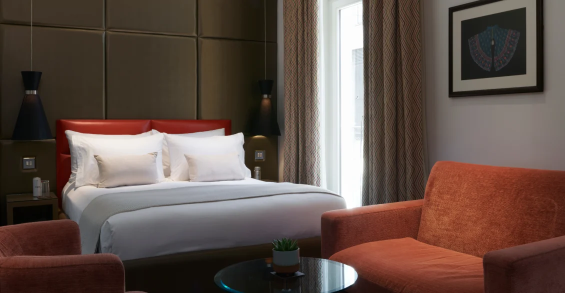 Premium King Deluxe room with a king bed, red cushion and orange armchairs