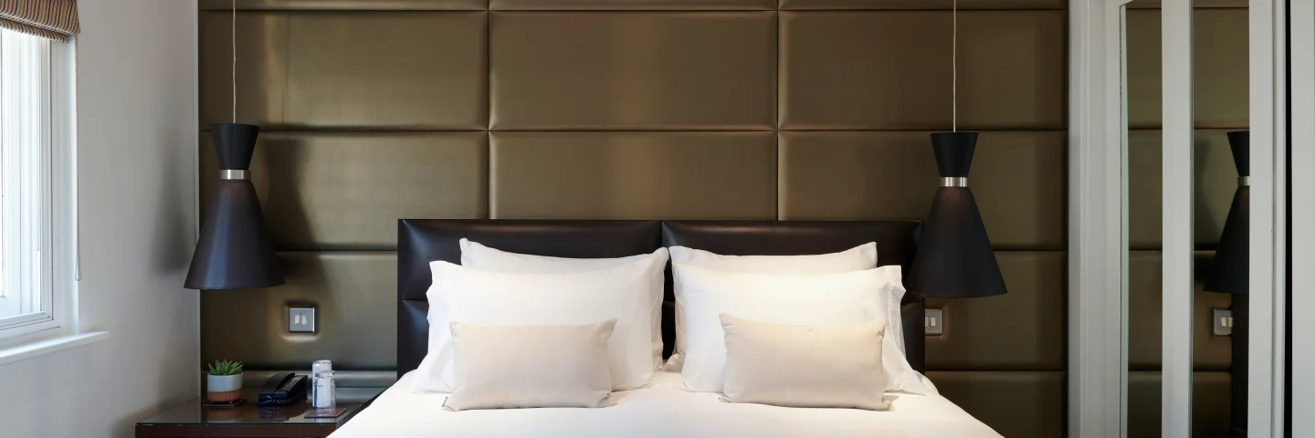 Premium King room with a padded headboard, pendant lights and a king bed
