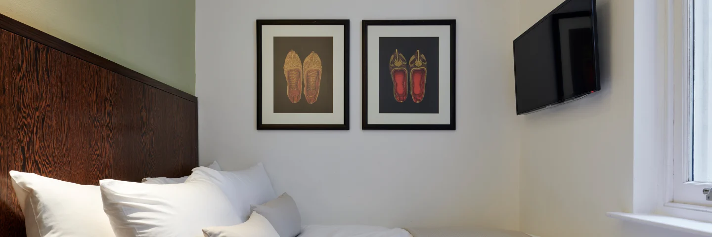 Standard Double room with a double bed, two framed prints and wall-mounted TV