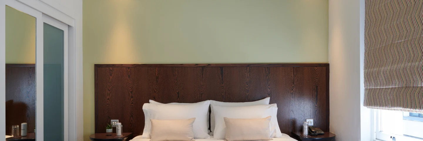 Premium King room with a king bed, dark wood headboard and green accent wall