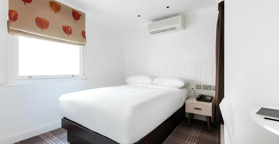 Superior Single room with a double bed, poppy-print blind and bedside table