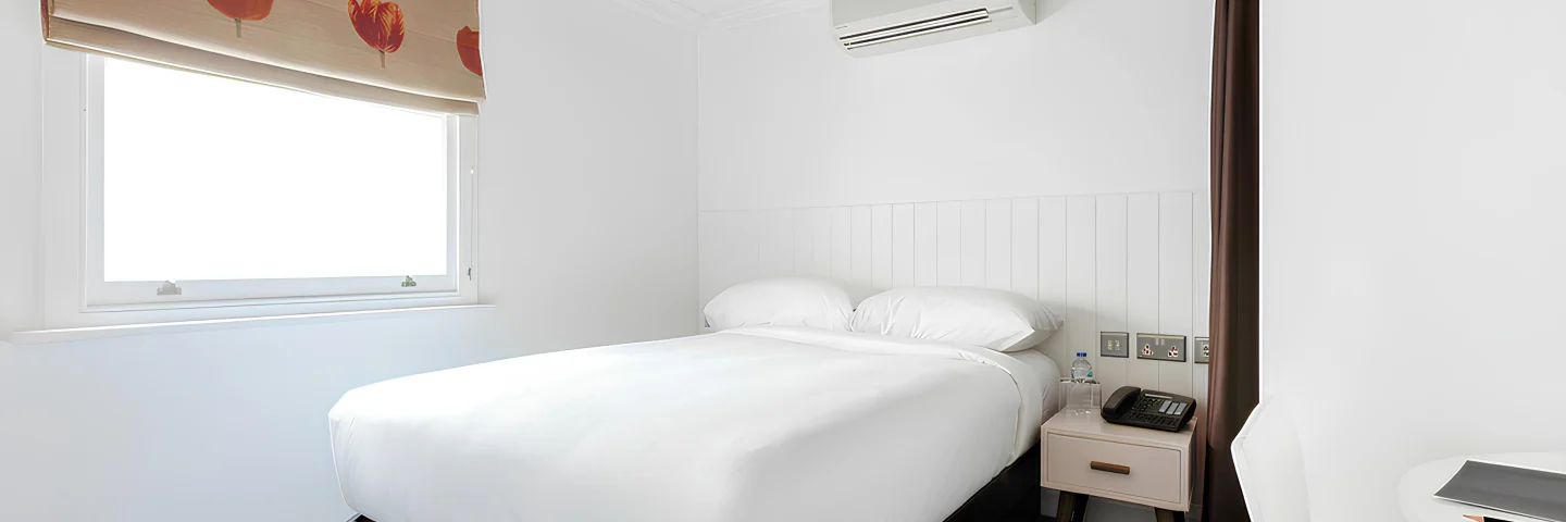 Superior Single room with a double bed, poppy-print blind and bedside table