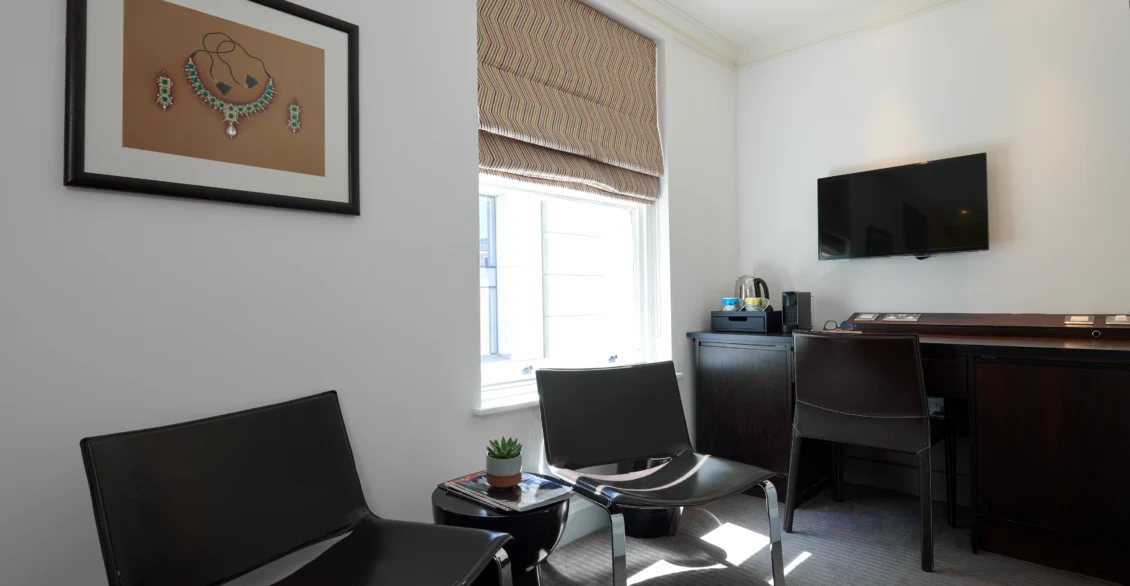 Sitting area in a Premium King room with leather chairs, desk and TV