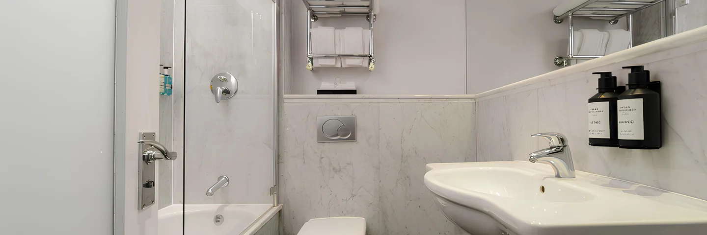 Marble bathroom with bath, shower screen and basin