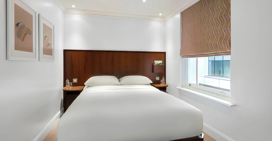 Standard Double room with a double bed, framed prints and roman blind