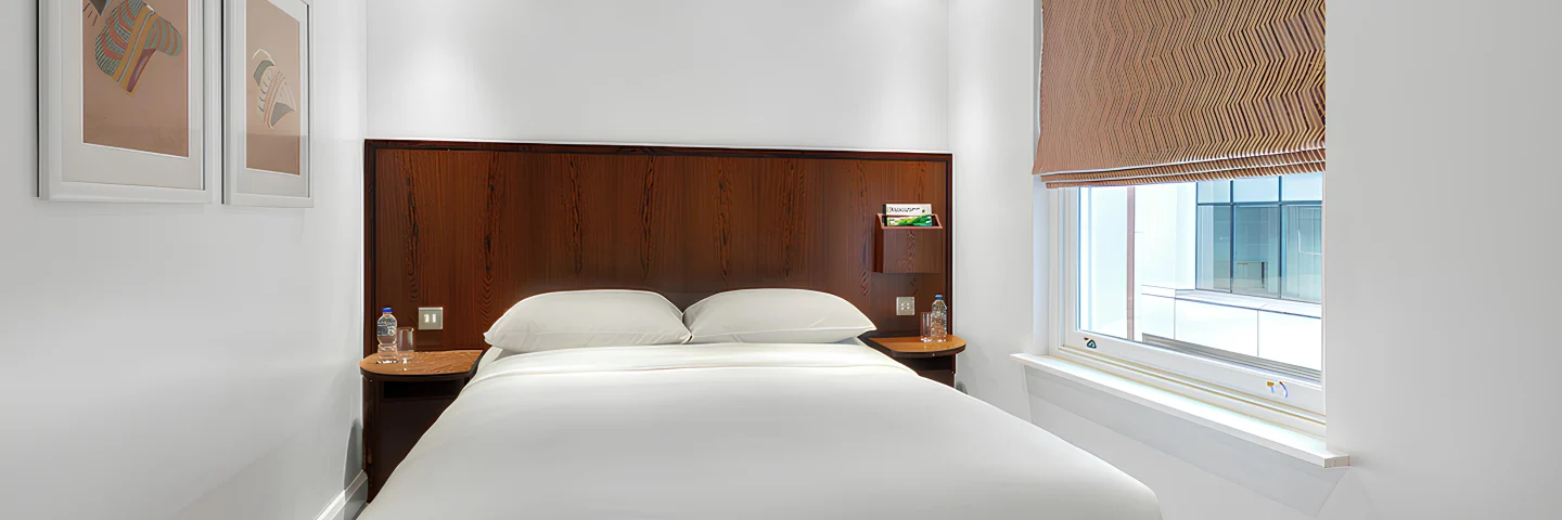 Standard Double room with a double bed, framed prints and roman blind