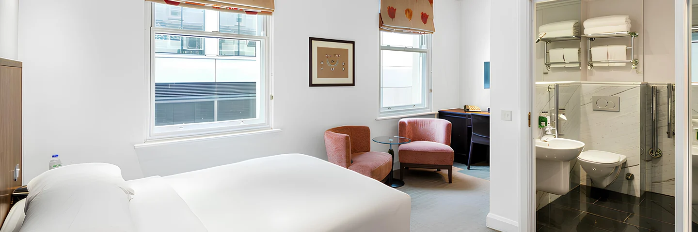 Accessible Double room with a double bed, armchair and open bathroom
