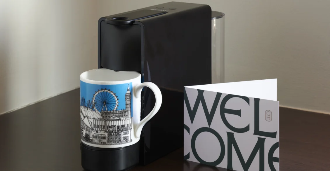 Guild Hotels London mug and a welcome card on a dark table