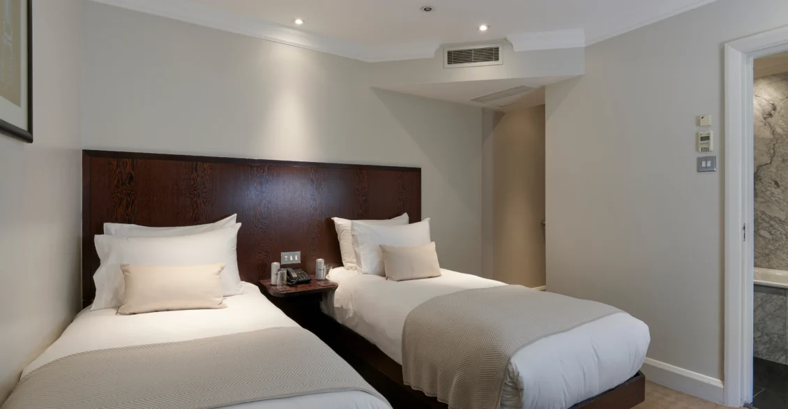 Standard Twin room with two single beds and a dark wood headboard