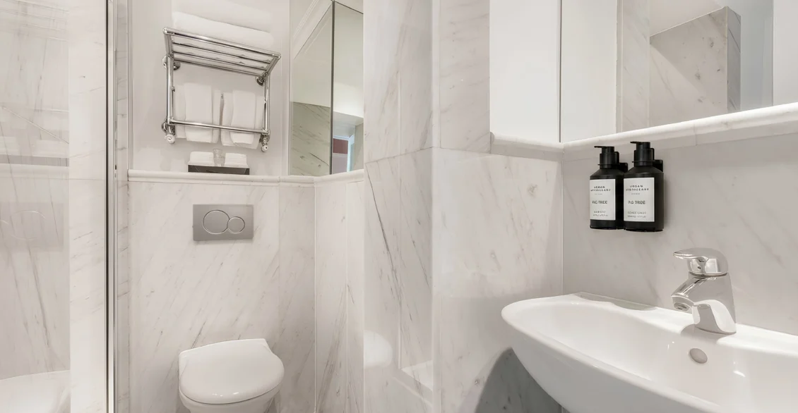 Marble bathroom with basin, mirror and towel rail