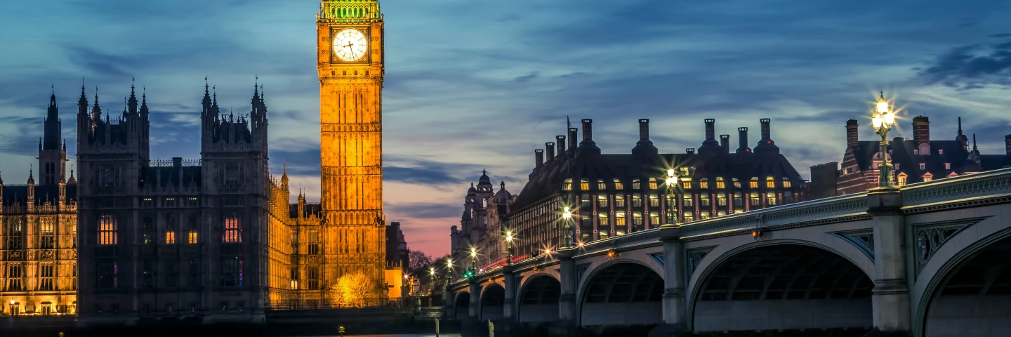 Big Ben and the Houses of Parliament lit at dusk, seen across the Thames