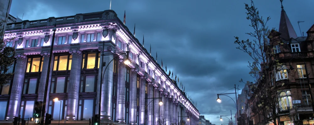 Selfridges department store on Oxford Street lit up at dusk