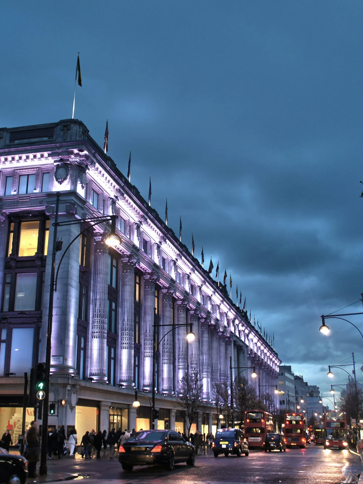 Selfridges department store on Oxford Street lit up at dusk
