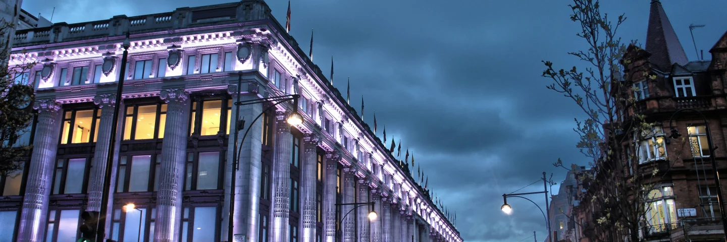 Selfridges department store on Oxford Street lit up at dusk