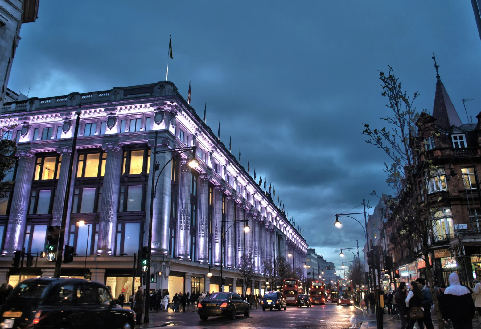 Selfridges department store on Oxford Street lit up at dusk