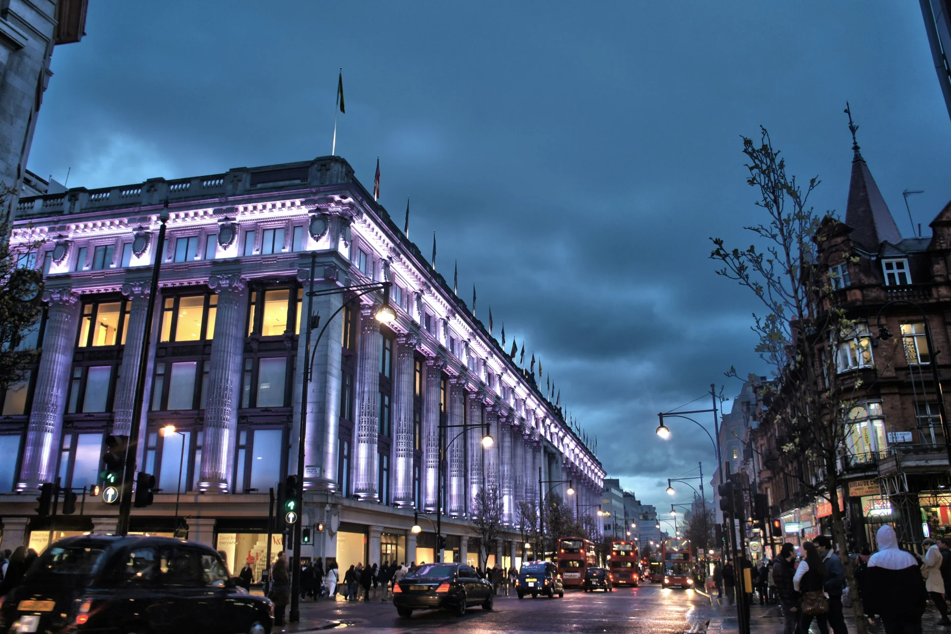 Selfridges department store on Oxford Street lit up at dusk
