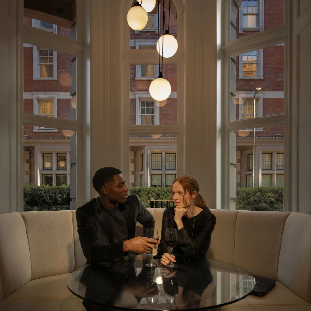 Couple enjoying drinks at a glass table in Bloomsbury Street Lounge