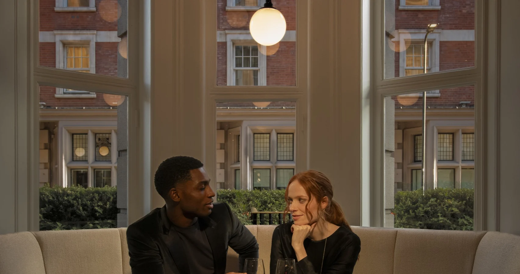 Couple enjoying drinks at a glass table in Bloomsbury Street Lounge
