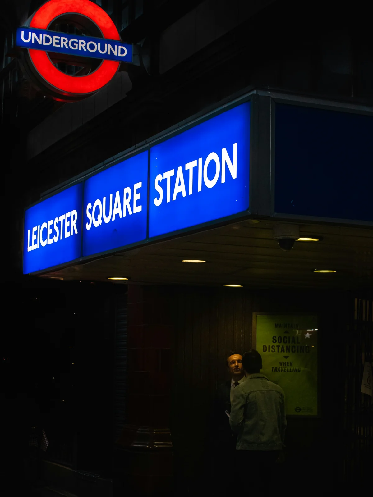 Illuminated Leicester Square Underground station sign at night