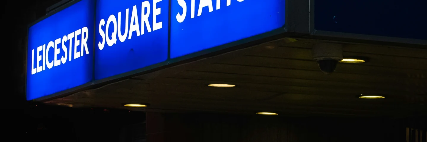 Illuminated Leicester Square Underground station sign at night