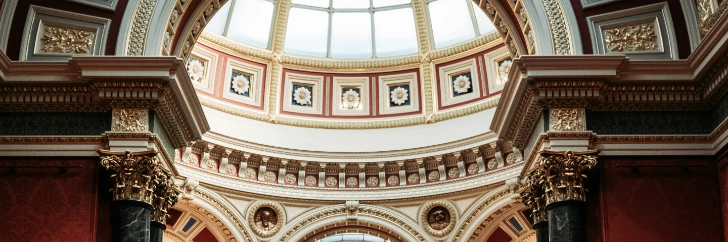 Ornate domed interior and red gallery walls at the National Gallery