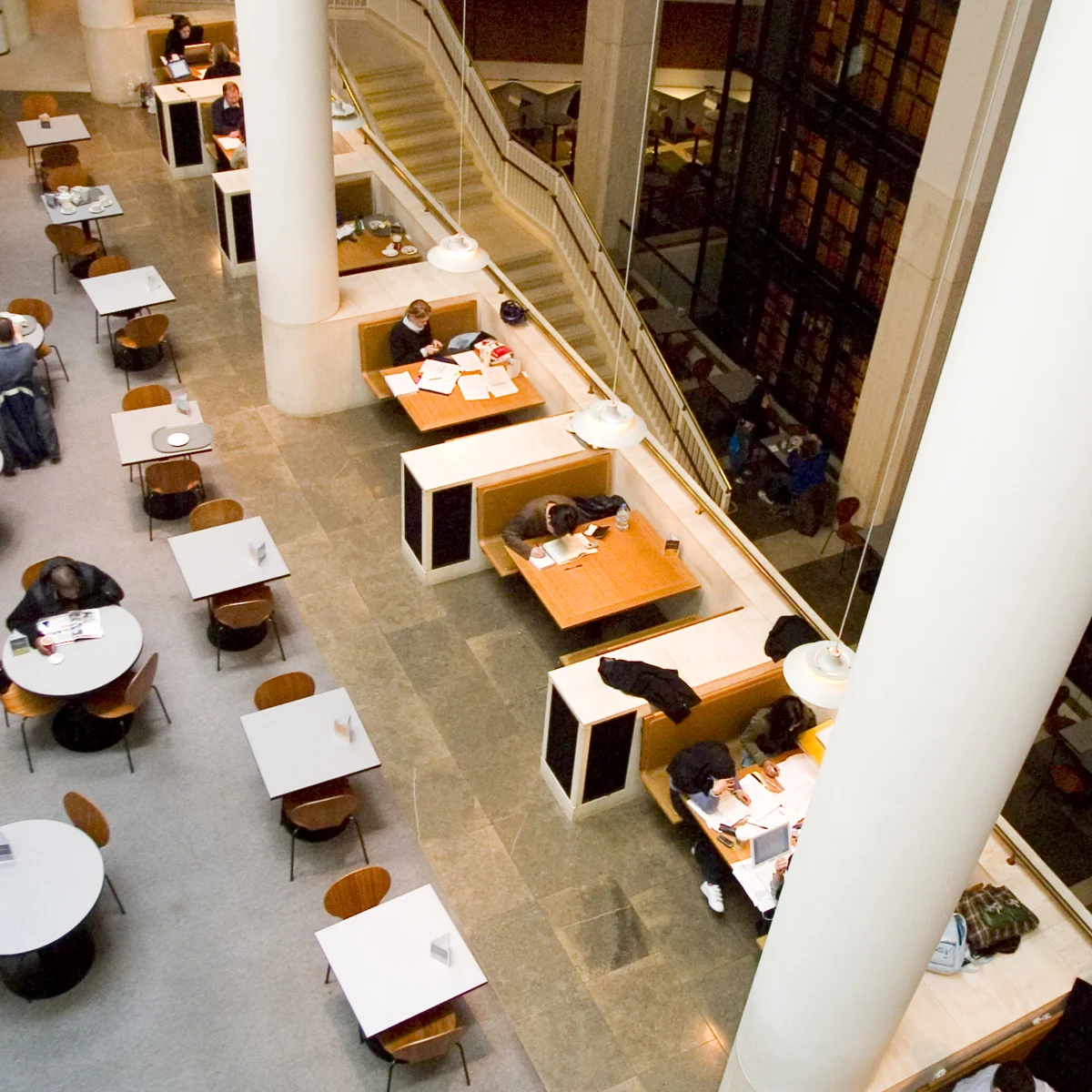 Reading tables beside tall bookshelves inside the British Library