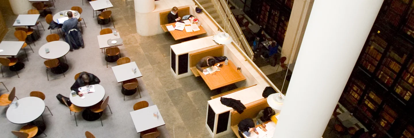 Reading tables beside tall bookshelves inside the British Library