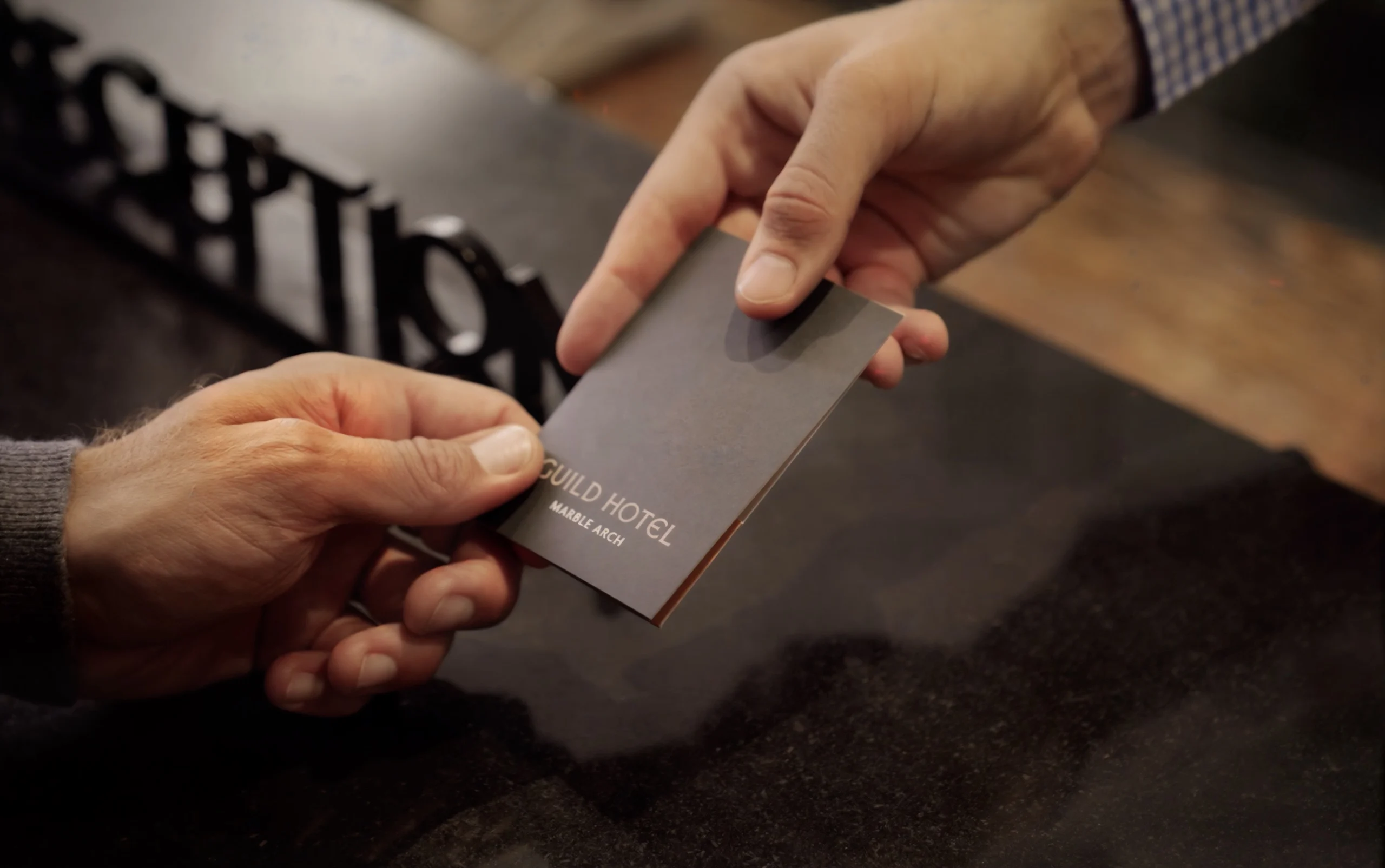 Guest receiving a key card at Guild Hotel Marble Arch