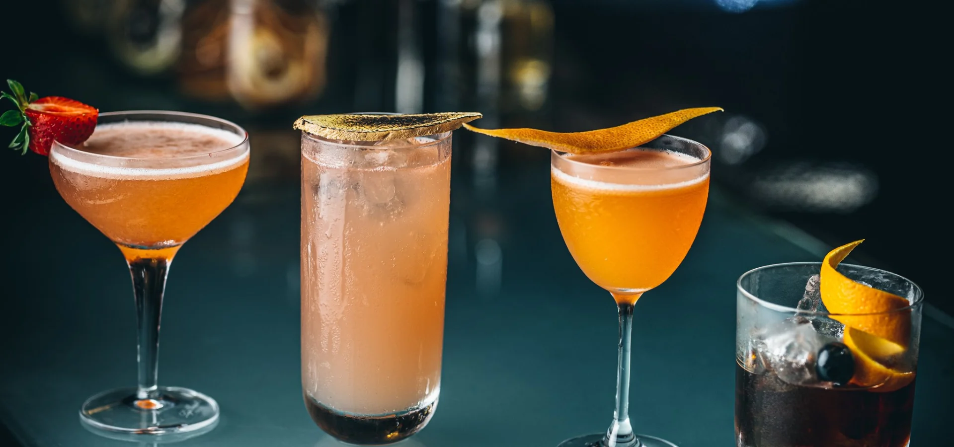 Four colourful cocktails arranged on the bar